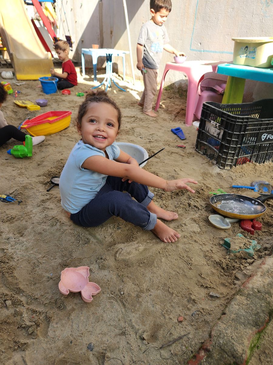 Menina sorrindo no tanque de areia